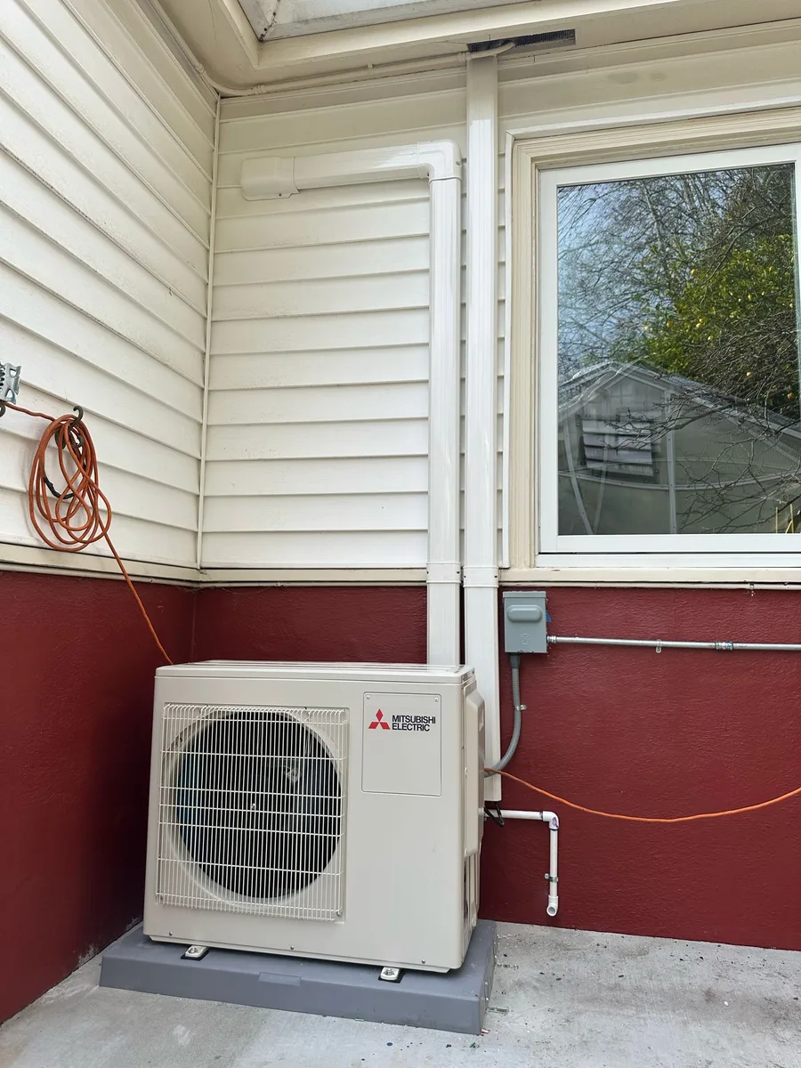 Mitsubishi outdoor heat pump condenser installed on a concrete pad in Berkeley